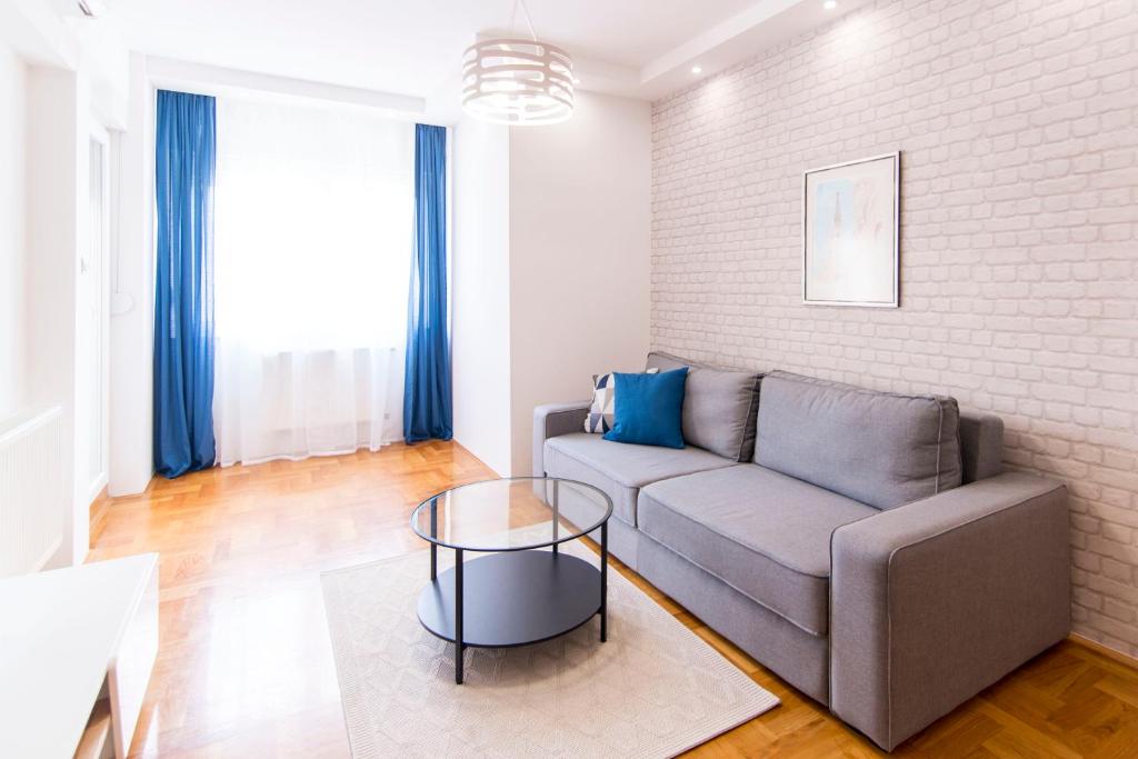 a living room with a couch and a table at Grove Apartment + Free Parking in Novi Sad