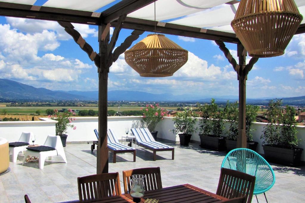 un patio con sillas, mesas y vistas. en Residenza storica con vista panoramica en Perugia