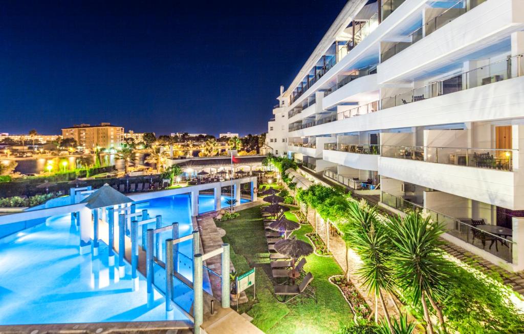 um edifício de apartamentos com piscina à noite em Ona Garden Lago em Port d'Alcudia