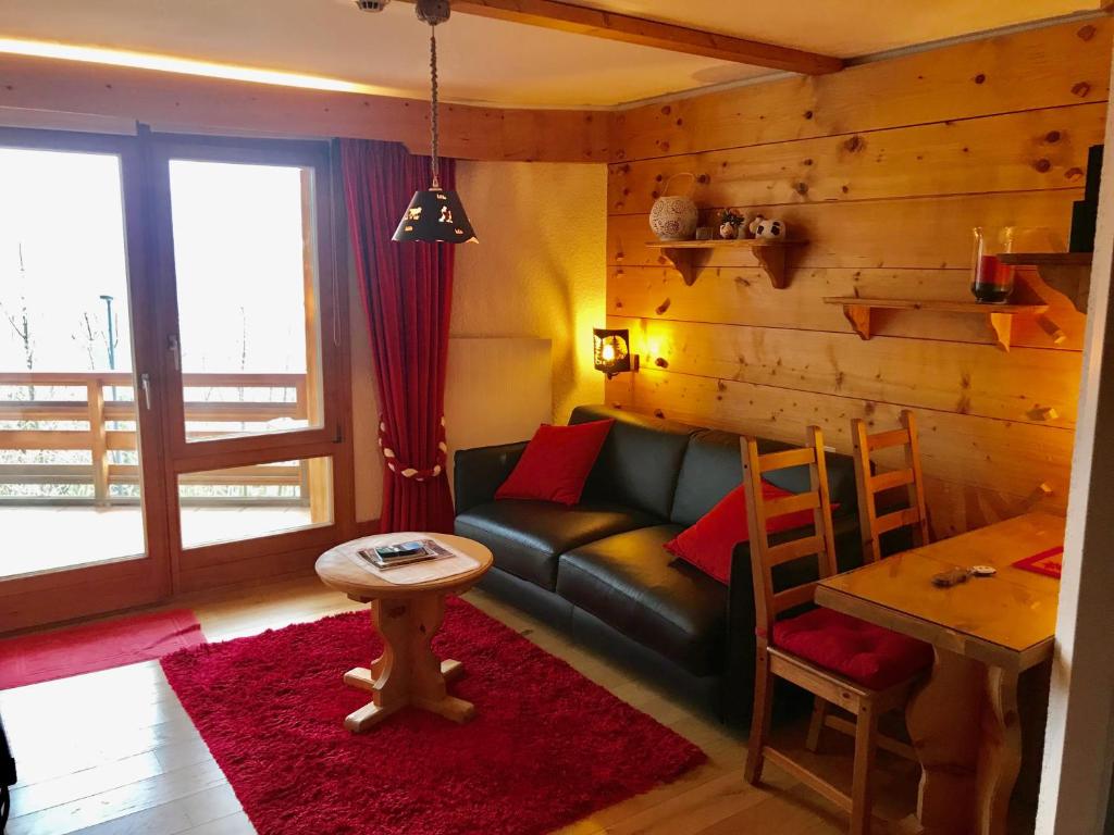 a living room with a couch and a table at Lovely Studio Bristol with swimming-pool Villars in Villars-sur-Ollon