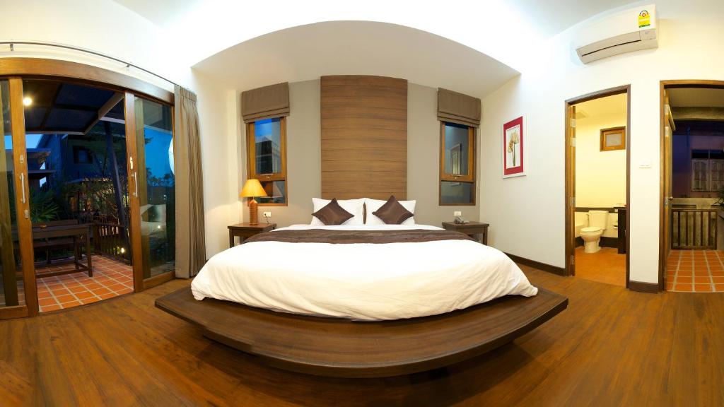 a bedroom with a large bed with a wooden floor at Dreamville Koh Phangan in Thong Sala