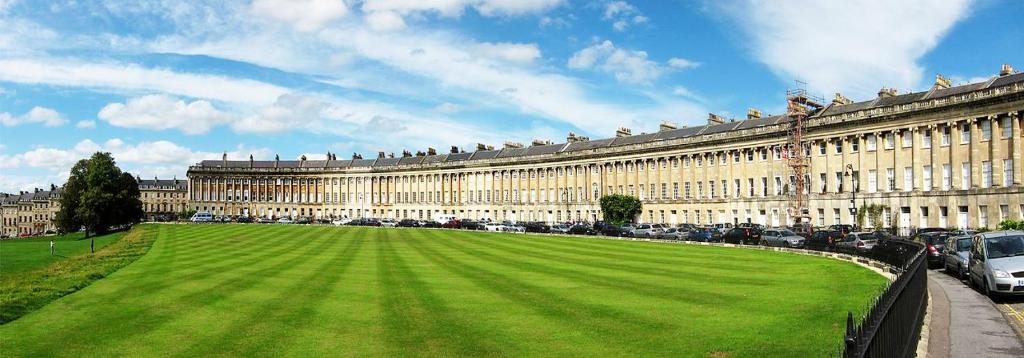 un gran edificio con un césped verde delante de él en Stunning Royal Crescent Apartment with 3 Bedrooms en Bath