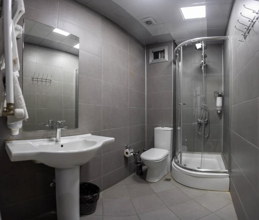 a bathroom with a sink and a shower and a toilet at Diplomat Suites in Baku