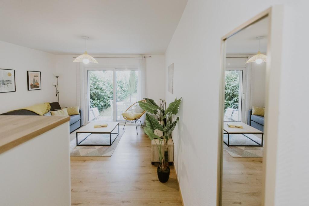 - un salon avec des murs blancs et un grand miroir dans l'établissement Appartement 4 personnes jardin et parking, à Vannes