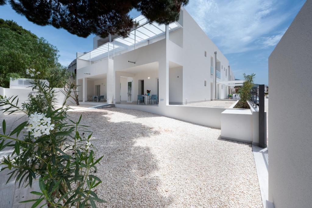 an exterior view of a white house with plants at Vitop Residence in San Vito lo Capo