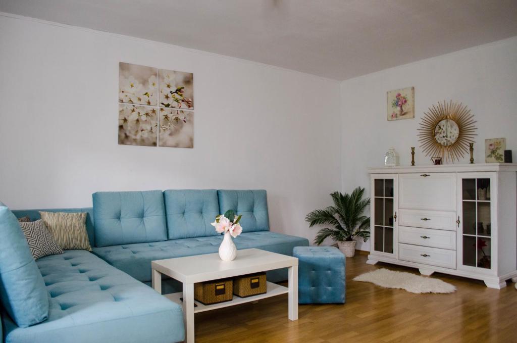 a living room with a blue couch and a table at Collosal Apartment with Garden in Bucharest