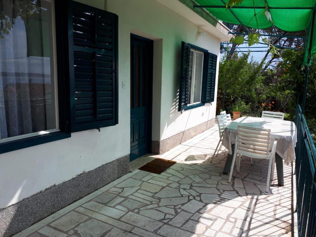 eine Terrasse mit einem Tisch und Stühlen auf einem Haus in der Unterkunft Apartmani Neda in Trogir