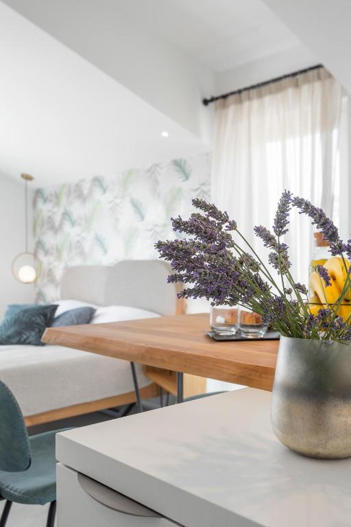 a living room with a table with a vase with flowers at Hvar Top View Apartments in Hvar