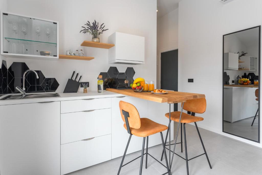 a kitchen with white cabinets and a wooden table and chairs at Hvar Top View Apartments in Hvar