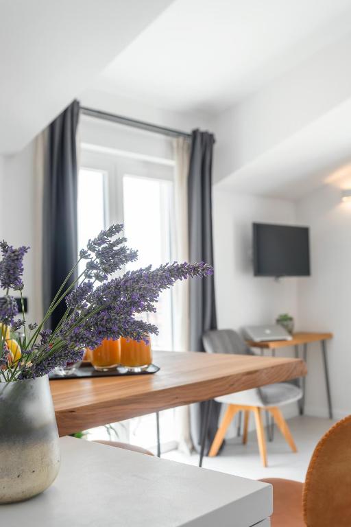 a living room with a wooden table with purple flowers at Hvar Top View Apartments in Hvar