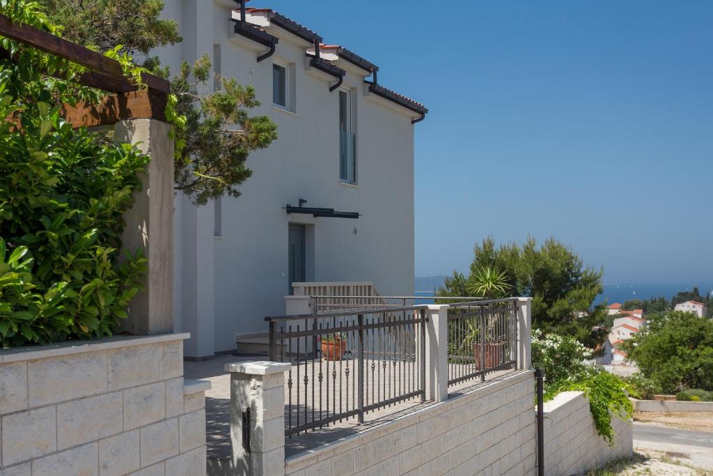 a white house with a gate and a balcony at Hvar Top View Apartments in Hvar