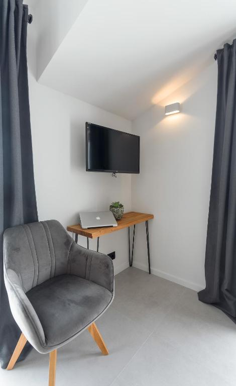 a room with a chair and a desk with a television at Hvar Top View Apartments in Hvar