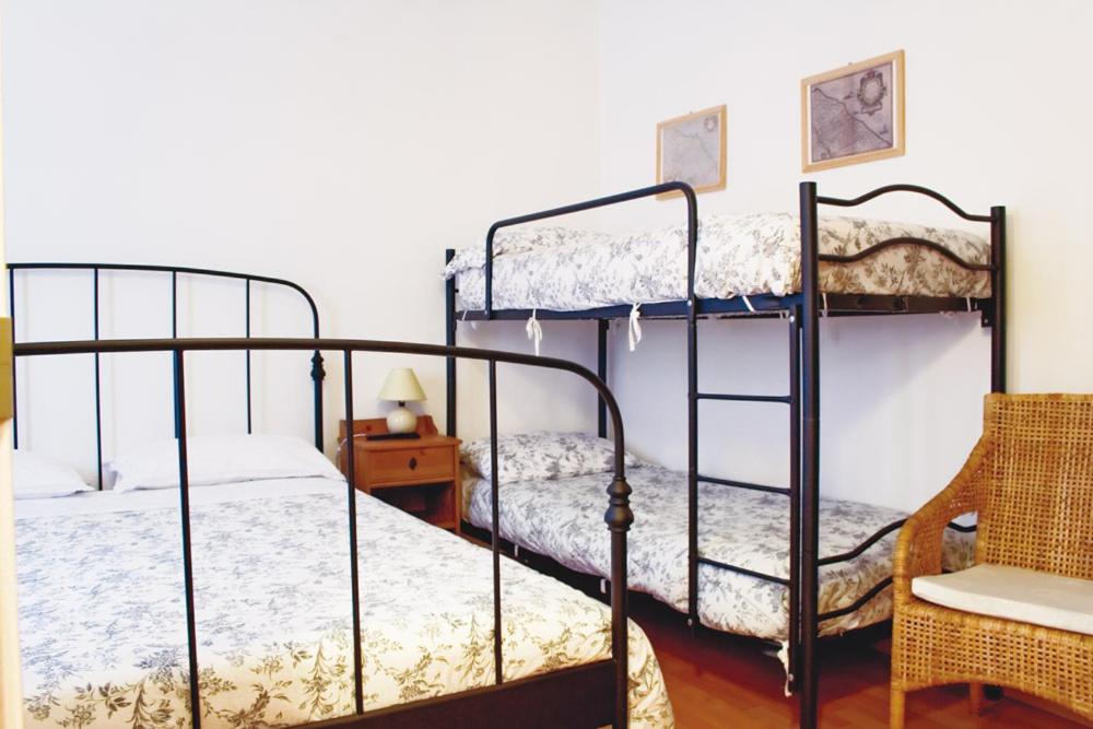 チヴィタノーヴァ・マルケにあるB&B Indipendenzaのベッドルーム1室(二段ベッド2台、椅子付)
