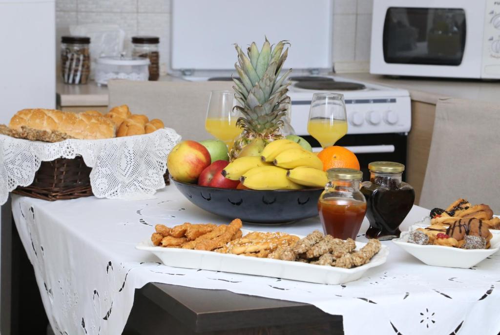 a table full of food and fruit on a counter at Angel Luxury Apartments in Keramoti