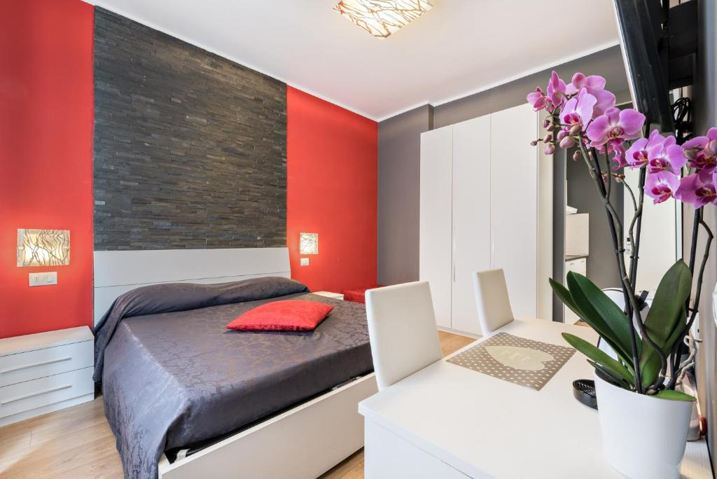 ラ・スペツィアにあるアフィッタカメレ マイ ホームの赤いアクセントの壁のベッドルーム1室、ベッド1台が備わります。