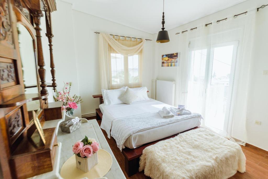 1 dormitorio con cama, mesa y algunas ventanas en Akadimia Luxury Apartment, en Mytilini