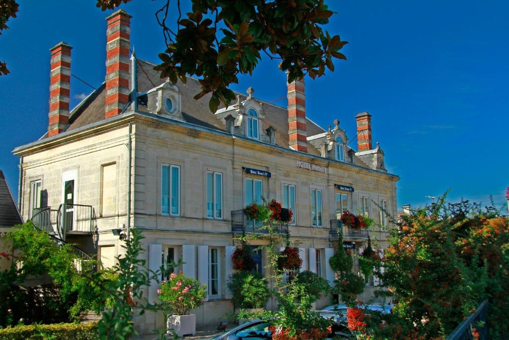an old house with three chimneys on top of it at Hotel Henri IV in Coutras