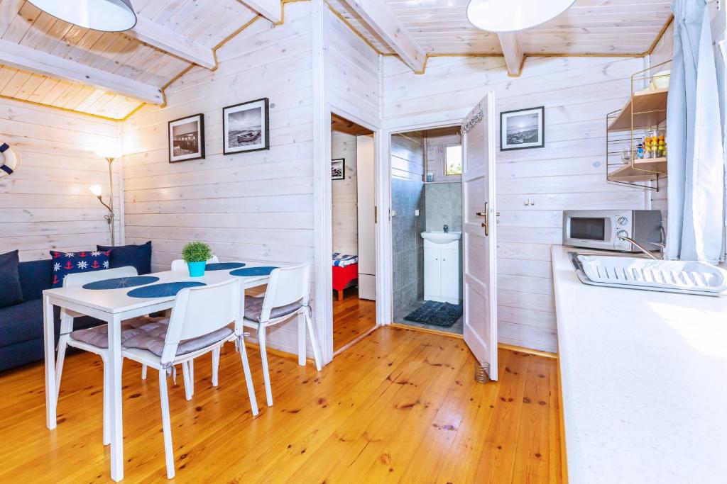 a kitchen and dining room with a table and chairs at Domki DanTom in Władysławowo