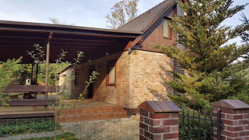 uma casa de tijolos com um banco e uma cerca em Dom wakacyjny em Boszkowo