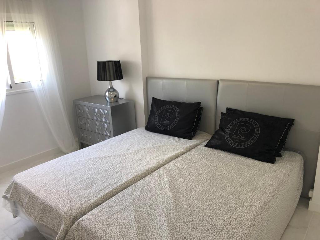 um quarto com uma cama com duas almofadas em Bubu Beach 1-B em Los Cristianos