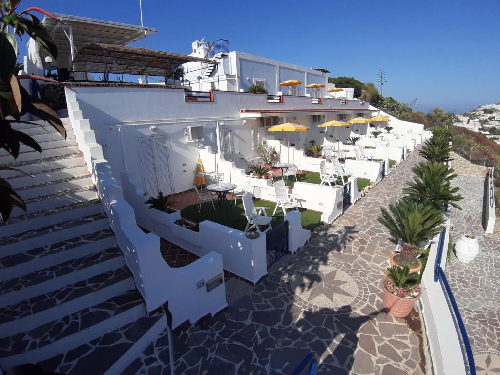un edificio con sillas y mesas blancas en una playa en Villa Flavia - Adults Only, en Ponza