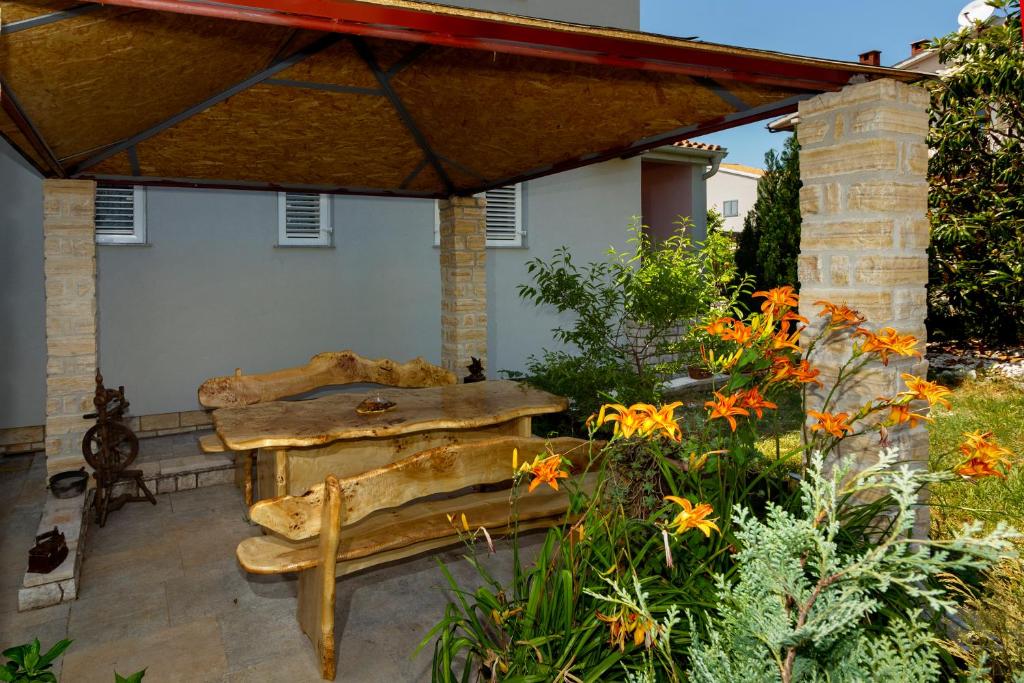 a patio with a table and a bench and flowers at Apartment Erceg in Poreč