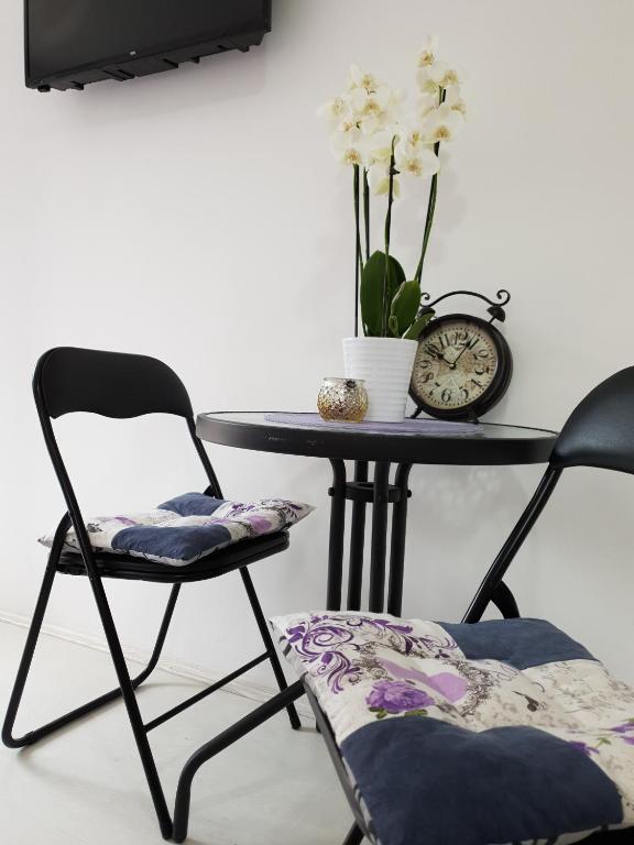 a table with two chairs and a table with a clock at Vila Stefanovic in Soko Banja