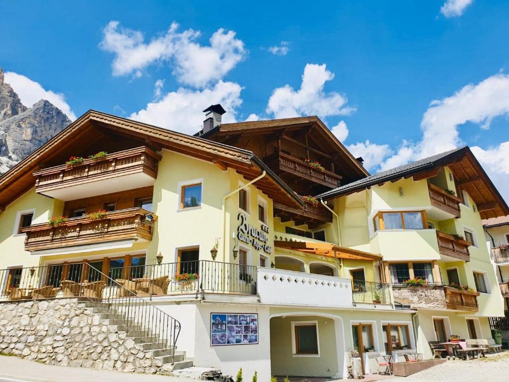 a building in the mountains with a blue sky at B&B Bracun in Corvara in Badia