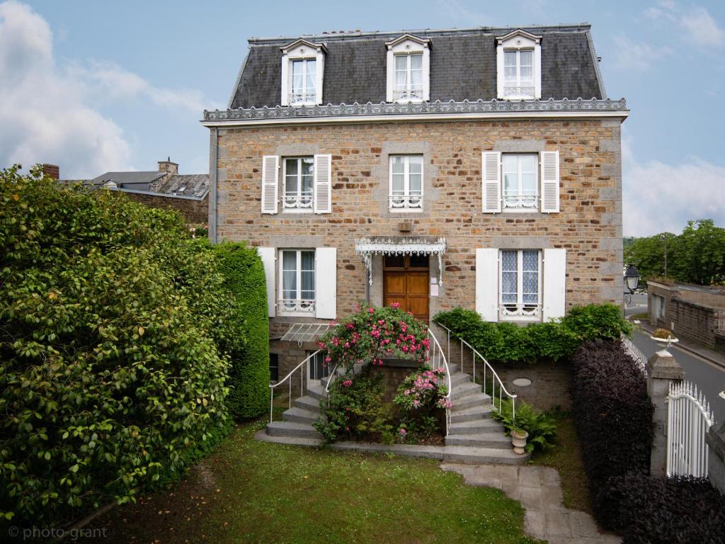 Cette grande maison en briques est accessible par un escalier. dans l'établissement Maison d'hôtes de charme La Rose de Ducey près du Mont Saint Michel, à Ducey
