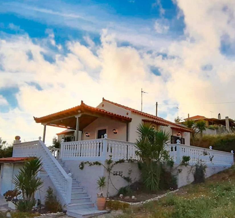 a white house with stairs in front of it at Nature Villa in Volímai