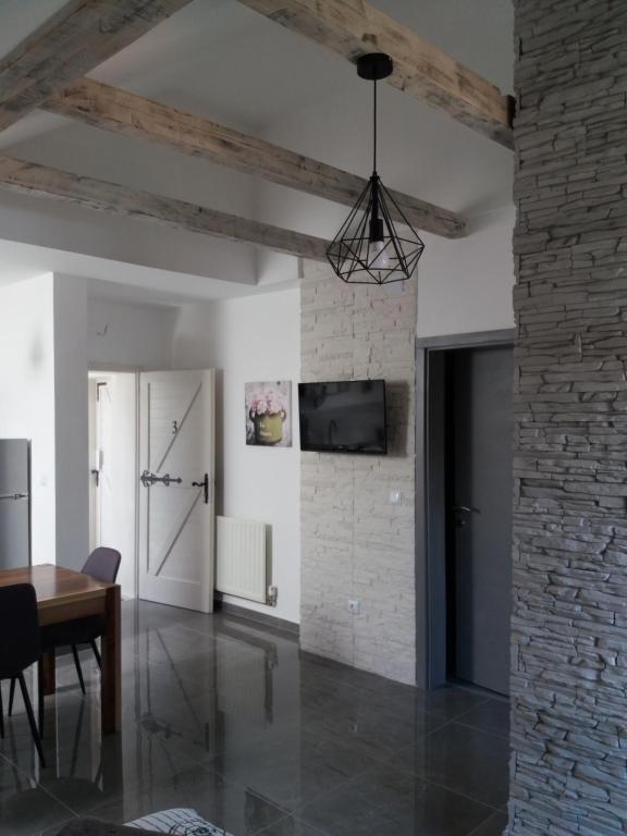 une salle à manger avec une table et un mur en briques dans l'établissement Studio apartman GRIZZLY, à Slunj