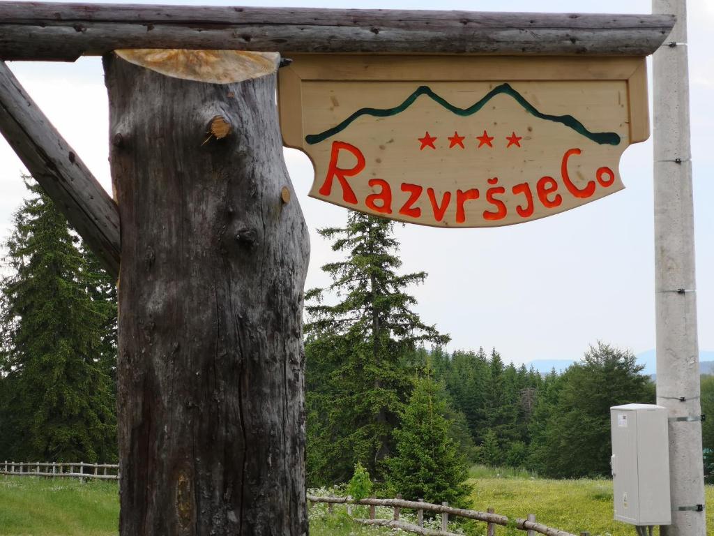 un cartel en un árbol al lado de un poste en Razvršje Co en Žabljak