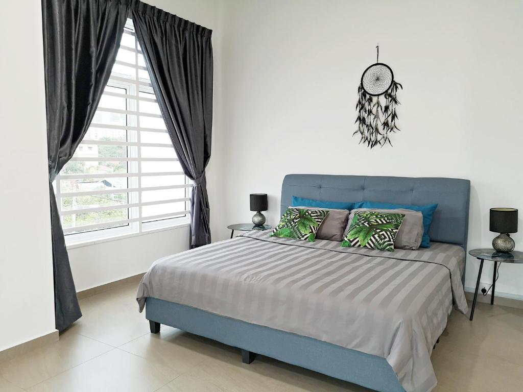 a bedroom with a blue bed and a window at Urban Space in Melaka