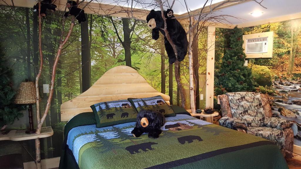 a bedroom with a bed with a stuffed bear on it at Bear Cove Inn in Saint Ignace