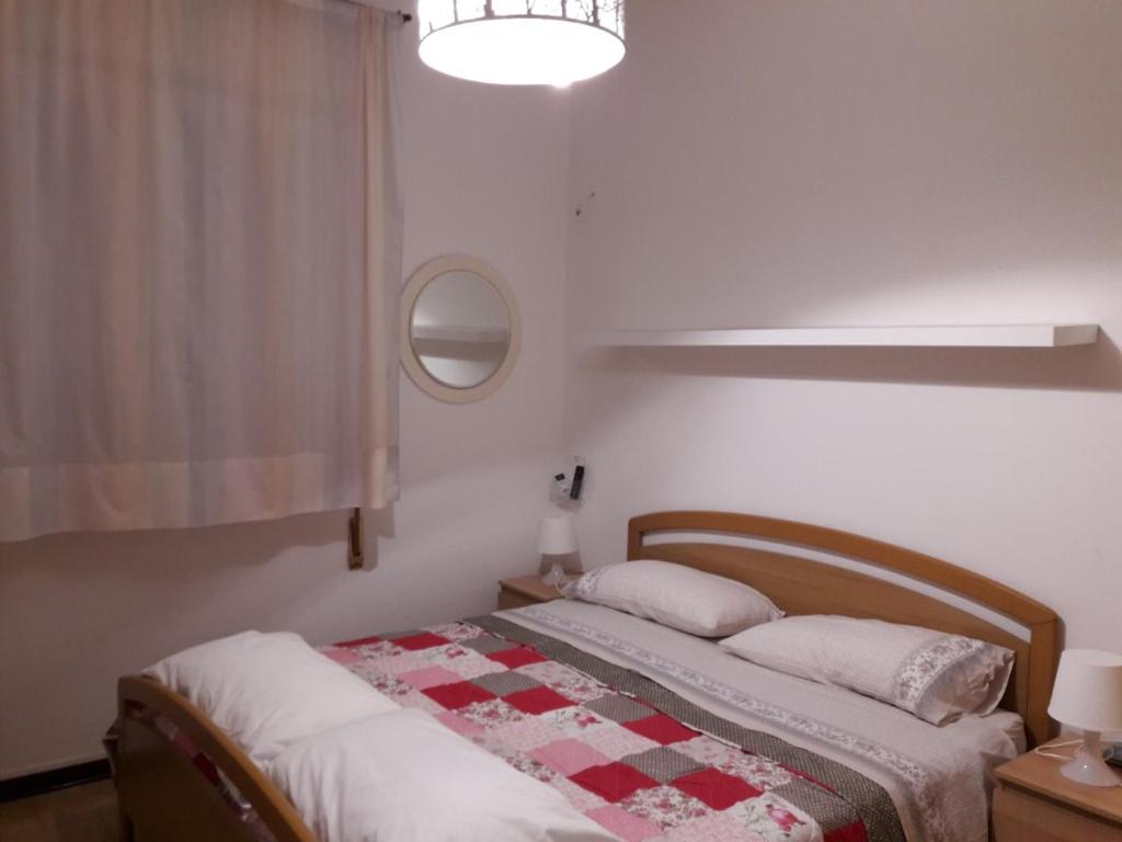 a bedroom with a bed with a red and white quilt at numero uno in Lido di Jesolo