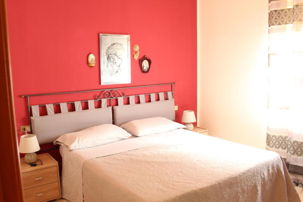 トラッペートにあるpaccolinosummerの赤い壁のベッドルーム1室、ベッド1台が備わります。