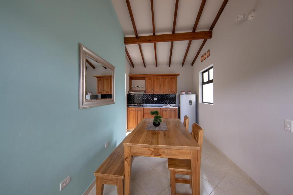 cocina con mesa de madera y nevera en Apartamentos Primavera en Jardín