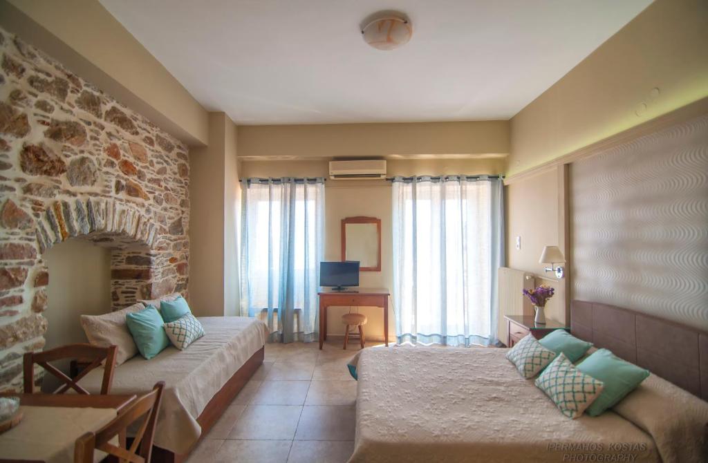 uma sala de estar com um sofá e uma parede de pedra em Ostria em Hermópolis