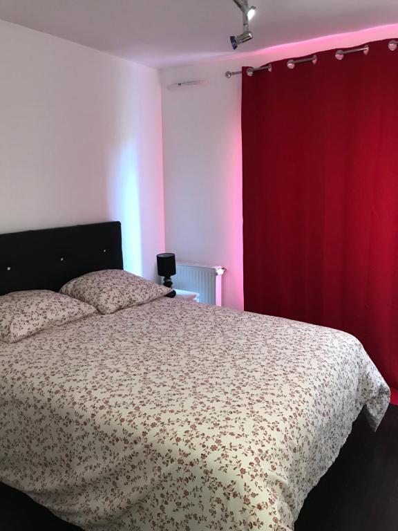 - une chambre avec un lit et un rideau rouge dans l'établissement chambre d'hote Disneyland esprit, à Bussy-Saint-Georges