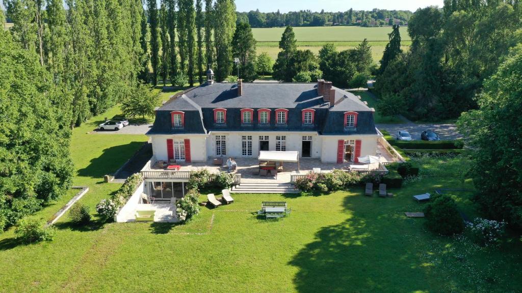 une vue aérienne sur une grande maison sur un champ verdoyant dans l'établissement Le domaine de barbizon, à Saint-Martin-en-Bière