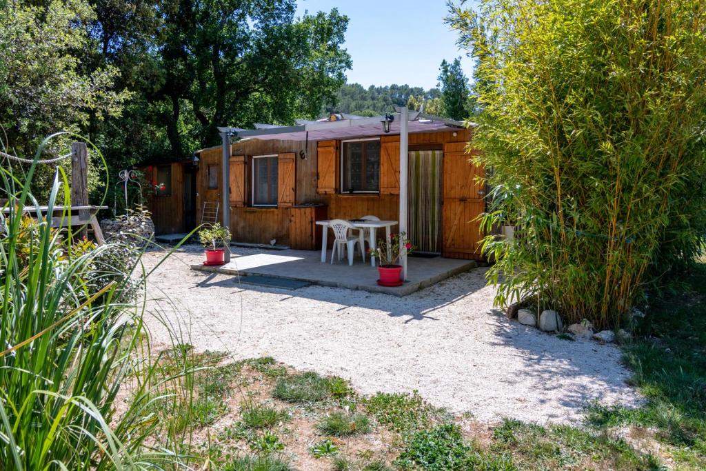 a tiny house in a garden with a patio at Le Chalet de l'Uzège - Piscine, détente et ballades in Belvézet