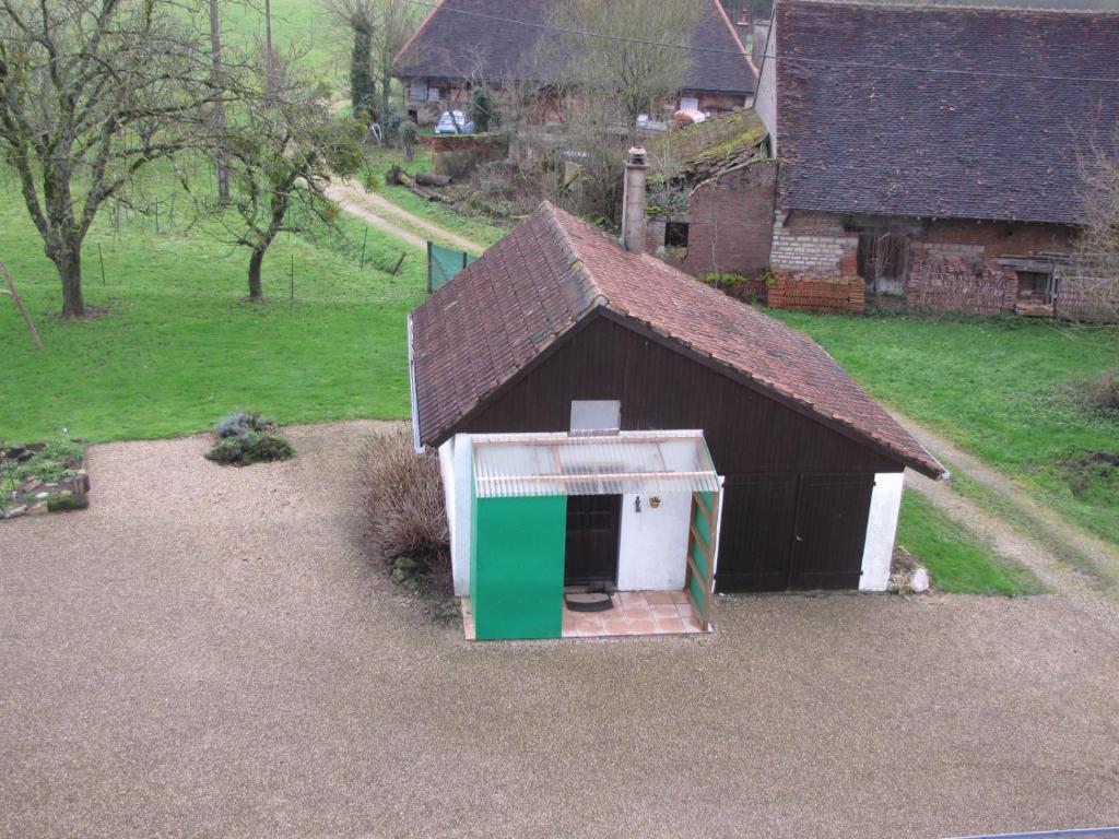 un piccolo fienile con una porta bianca e verde di 487 Rue des Grappins a Bouhans