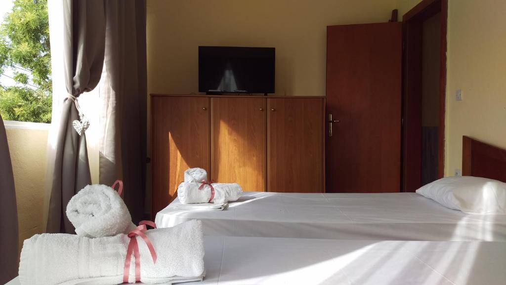 two stuffed animals sitting on two beds in a bedroom at Dimitris & Vassiliki's apartment in Possidi