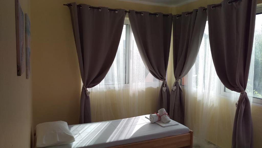 a bedroom with a bed and a window with curtains at Dimitris & Vassiliki's apartment in Possidi