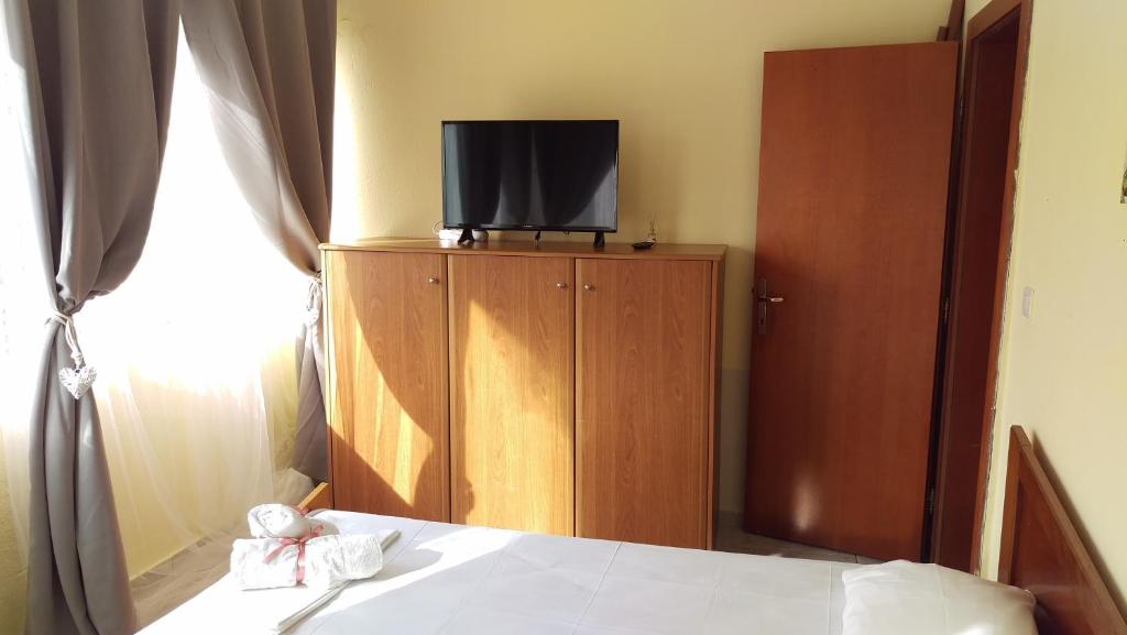 a bedroom with a bed and a tv on a cabinet at Dimitris & Vassiliki's apartment in Possidi