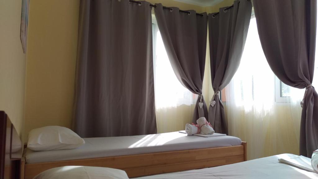 a bedroom with two beds and a window with curtains at Dimitris & Vassiliki's apartment in Possidi