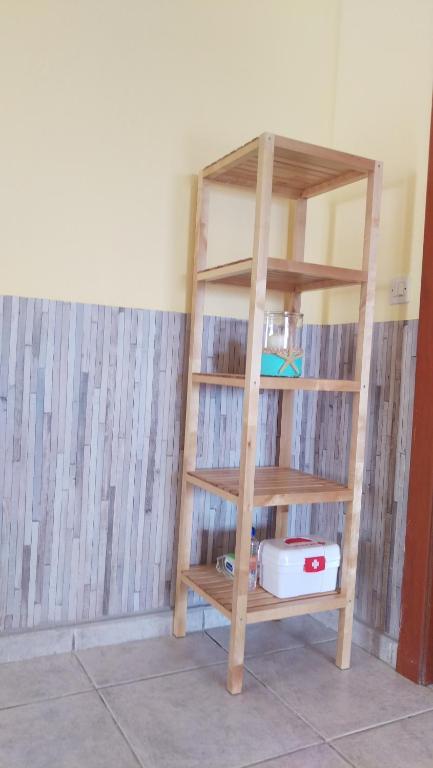 a wooden book shelf in a room with a wall at Dimitris & Vassiliki's apartment in Possidi