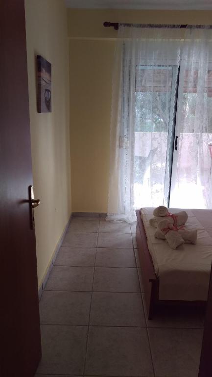 a bedroom with a bed in front of a window at Dimitris & Vassiliki's apartment in Possidi