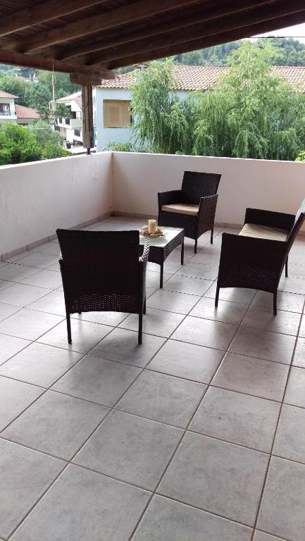 a patio with four chairs and a table and a table at Dimitris & Vassiliki's apartment in Possidi