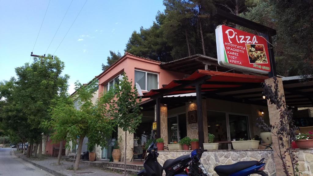 a pizza restaurant with a motorcycle parked in front of it at Dimitris & Vassiliki's apartment in Possidi